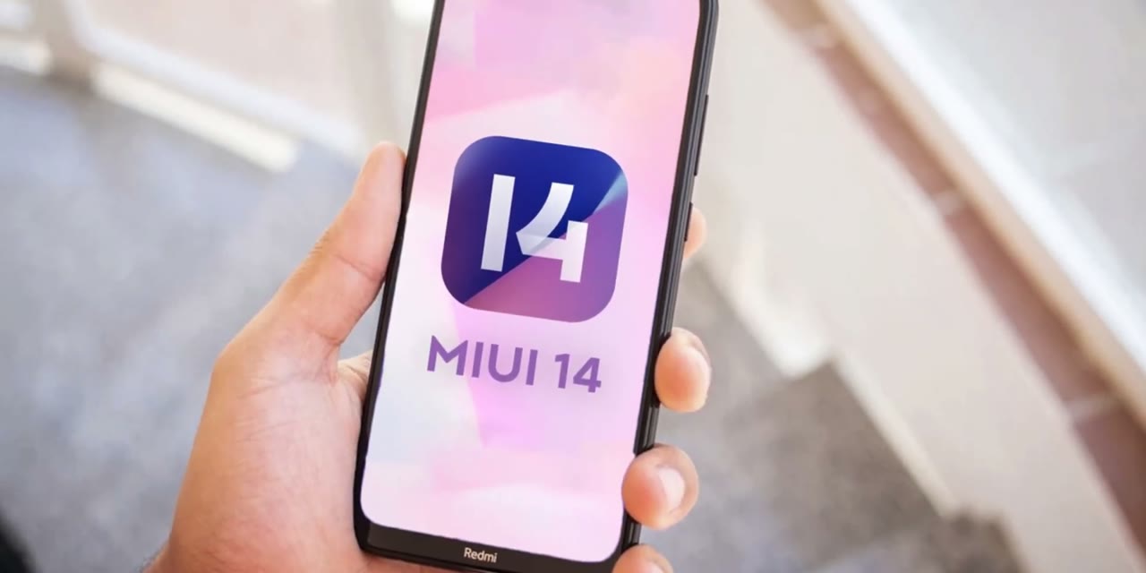 Celular Redmi en la mano mostrando el logo de MIUI 14