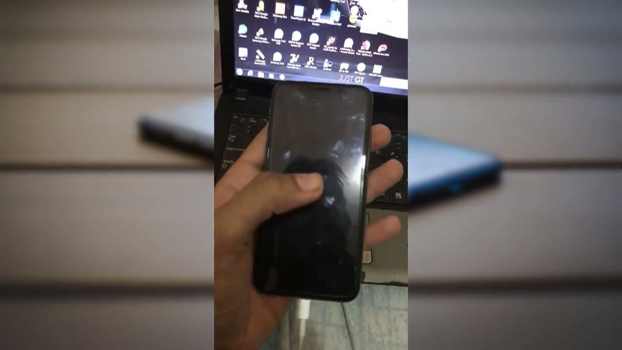 iPhone X con la pantalla totalmente negra, conectado por cable a una computadora portátil